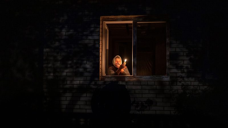 Die 70-Jährige Catherine steht während eines Stromausfalls in Borodjanka mit einer Kerze am Fenster.