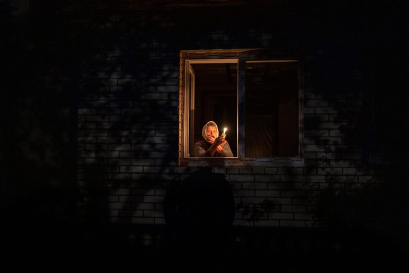 Die 70-Jährige Catherine steht während eines Stromausfalls in Borodjanka mit einer Kerze am Fenster.