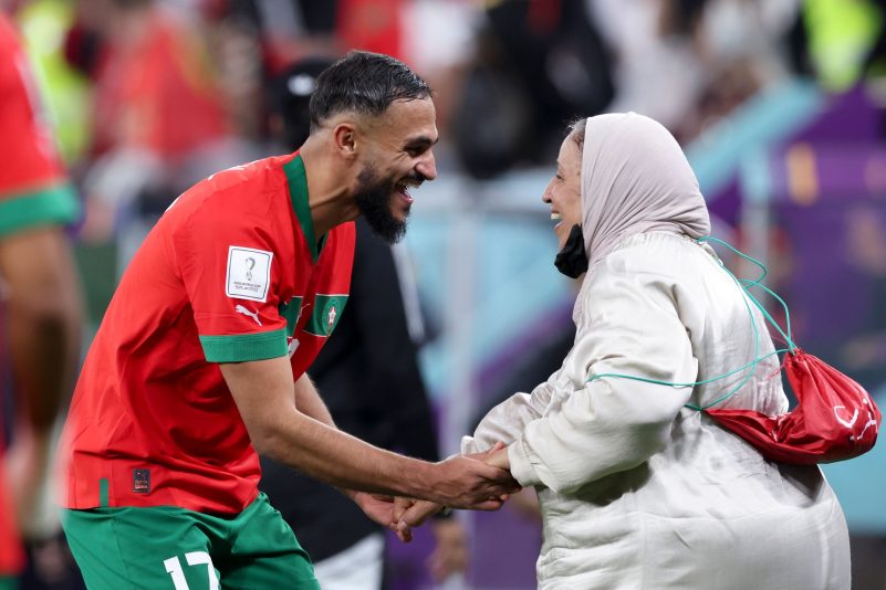 Marokkos Nationalspieler Sofiane Boufal (l.) tanzt nach dem Sieg gegen Portugal in Katar mit seiner Mutter auf dem Rasen.