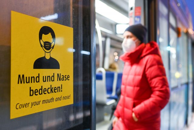 Eine Frau betritt mit FFP2-Maske eine Trambahn in München.