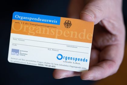 Eine Frau hält einen Organspendeausweis in ihren Händen.