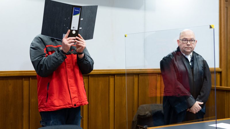 Der Angeklagte steht vor Beginn der Gerichtsverhandlung in einem Gerichtssaal im Landgericht Bückeburg.