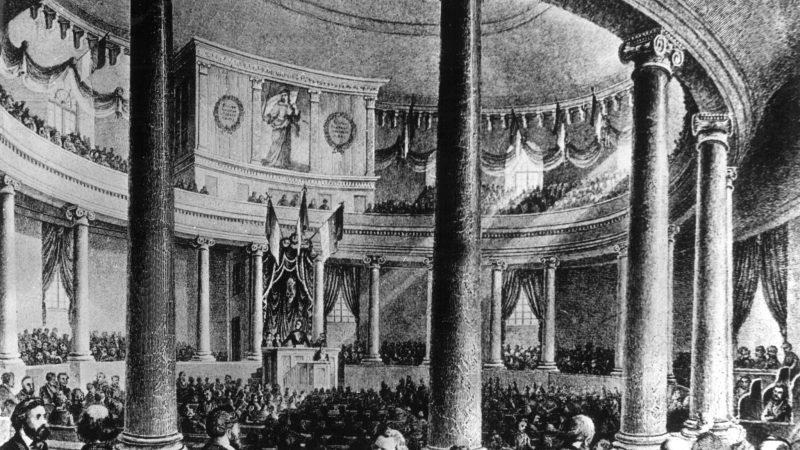 Die zeitgenössische Darstellung zeigt die erste Sitzung der Nationalversammlung, die von ihrem Präsidenten Heinrich von Gagern am 18. Mai 1848 in der Frankfurter Paulskirche eröffnet wurde.