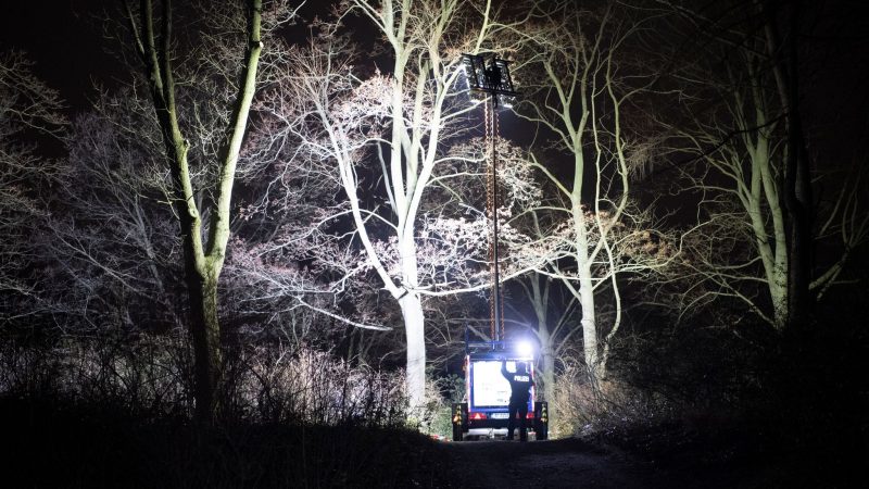 Polizisten beleuchten im Dunkeln einen Ort an einem Park in Pankow. Das vermisste vierjährige Mädchen aus Berlin ist tot. Es sei am Abend mit Verletzungen von Passanten im Bürgerpark Pankow gefunden worden, sagte ein Polizeisprecher.