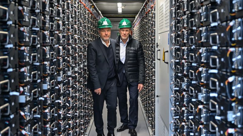 Bundeswirtschaftsminister Robert Habeck (l. Bündnis 90/Die Grünen) und Leag-Chef Thorsten Kramer stehen bei einem Rundgang über das Gelände vom Braunkohlekraftwerk Schwarze Pumpe in einem Batteriespeicher.