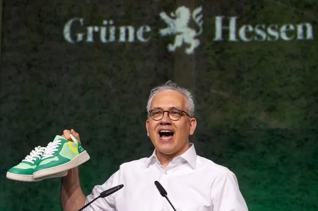Tarek Al-Wazir erhält als Geschenk ein Paar Turnschuhe. Diese sollen an den ersten grünen Minister im hessischen Kabinett erinnern, der in Turnschuhen zur Vereidigung kam.