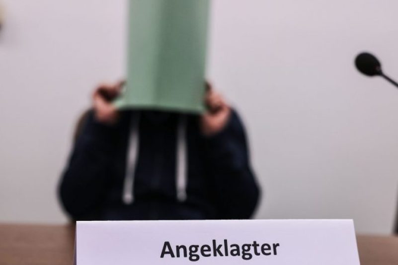 Der Angeklagte im Missbrauchskomplex Wermelskirchen hält sich im Gerichtssaal eine Mappe vor das Gesicht.