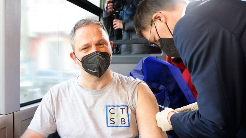 Bundesgesundheitsminister Karl Lauterbach (R) impft beim Start des Projekts am 10. März 2022 in Berlin einen Mann im sogenannten #Impfung-hilft-Tourbus mit dem „Corona-Impfstoff“.