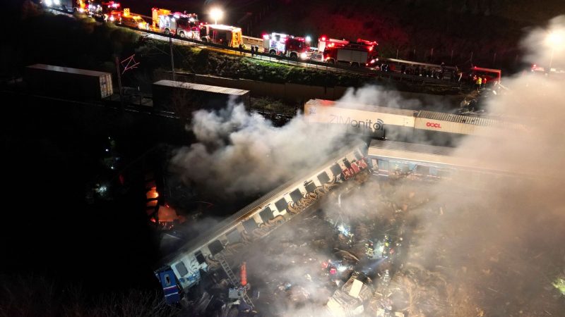 Rauch steigt auf, während Feuerwehrleute und Rettungskräfte nach dem Zusammenstoß zweier Züge nahe Larissa im Einsatz sind.