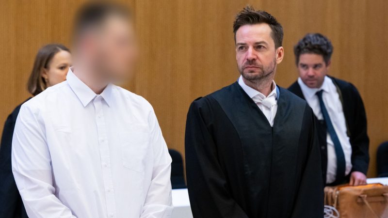 Einer von zwei wegen Mordes angeklagten Männern (l) neben seinem Rechtsanwalt im Landgericht München.