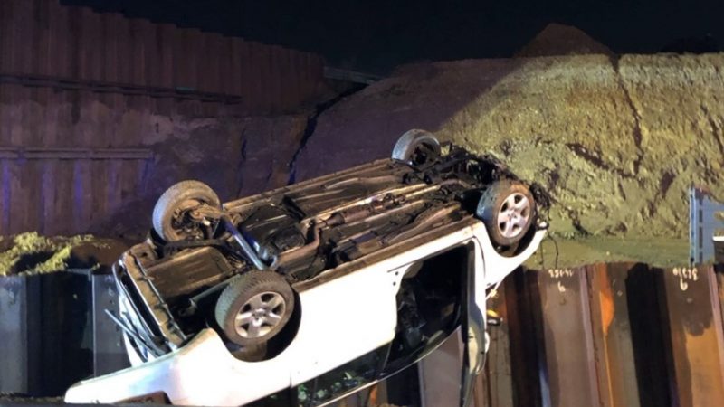 Ein Auto liegt auf dem Dach, nachdem es von einer demontierten Autobahnbrücke gestürzt ist. Der Fahrer wurde leicht verletzt.