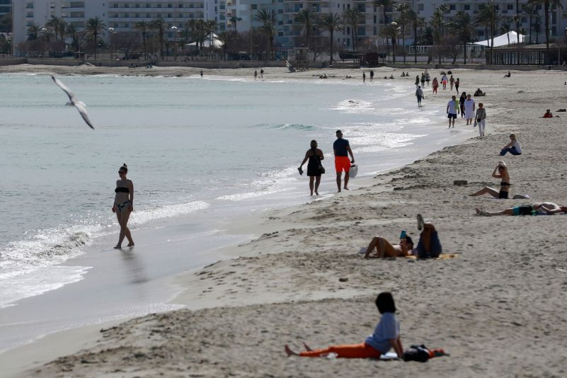 Menschen sonnen sich am Strand von Cala Millor auf Mallorca.