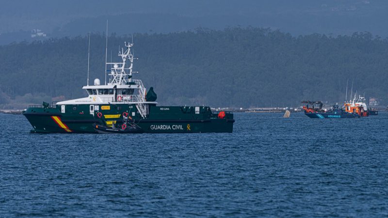 Schiffe der Guardia Civil und des Zolls beteiligen sich an der Bergung eines mutmaßlichen Drogen-U-Boots, von dem nur eine Spitze aus dem Wasser ragt.