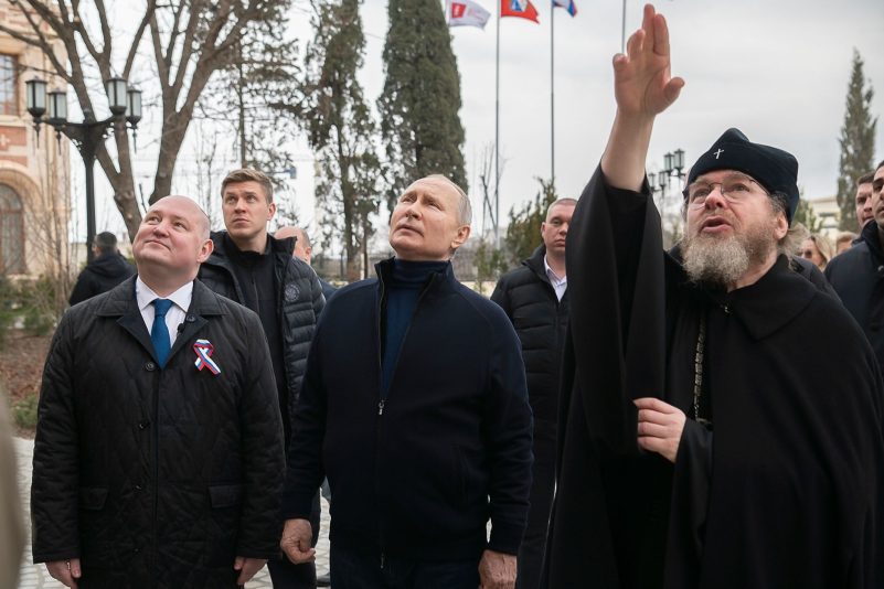 Kremlchef Putin ist zum neunten Jahrestag der russischen Annexion der Krim zu einem unangekündigten Besuch auf der Schwarzmeer-Halbinsel eingetroffen. Hier zusammen mit dem Gouverneur von Sewastopol, Michail Raswoschajew und Bischof Tichon beim Besuch einer Kunstschule für Kinder.