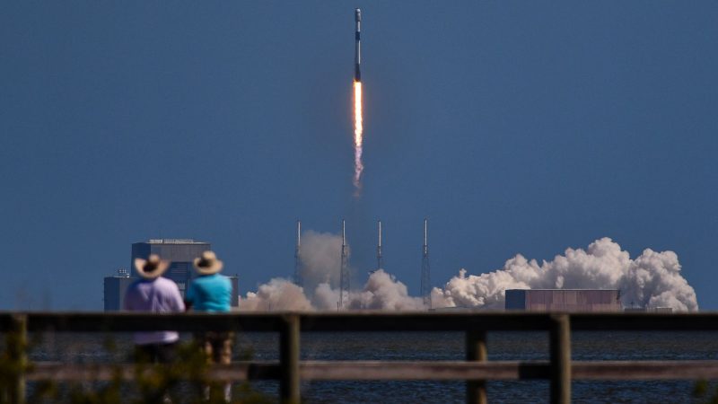 Menschen beobachten den Start einer SpaceX Falcon 9-Rakete mit Starlink-Satelliten an Bord, die von der Cape Canaveral Space Force Station in Florida abhebt.