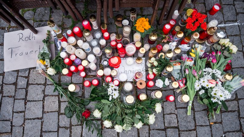 Auf dem Platz vor dem Blumengeschäft sind Blumen und Kerzen als Zeichen der Trauer niedergelegt.