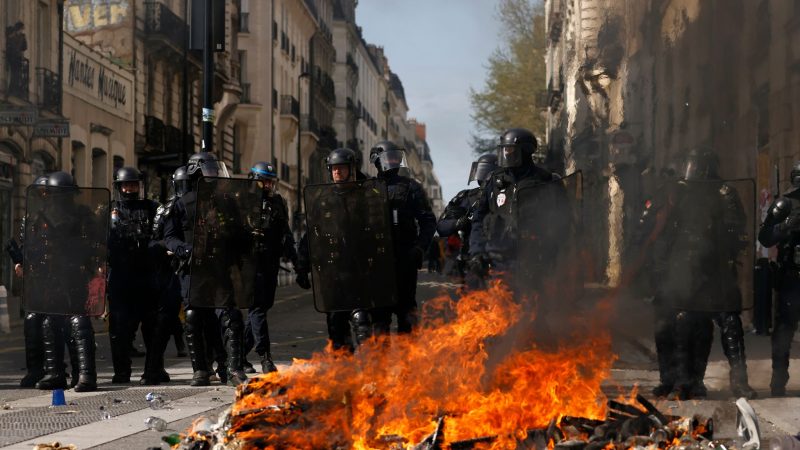 Bereitschaftspolizisten hinter einer brennenden Barrikade in Nantes