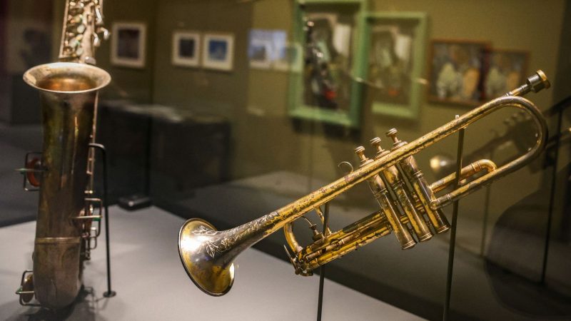 Ein Saxophon (l) und eine Trompete aus den 1920er Jahren sind in einer Vitrine ausgestellt.
