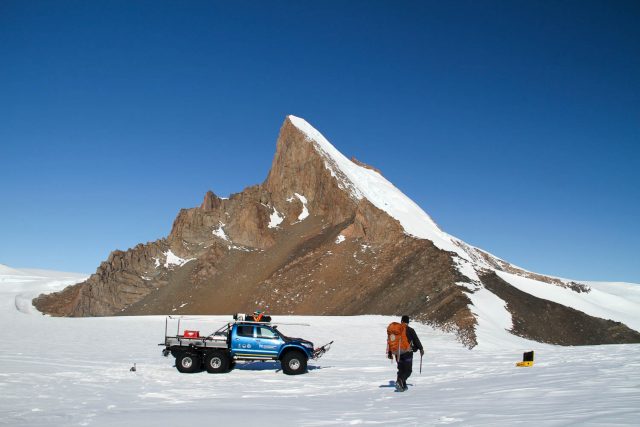 Nat Lifton sucht vor dem „Cottontop Mountain“ nach Gesteinsproben. Der Pickup dient dem Transport von Mensch und Material von und zur norwegischen Antarktis-Forschungsstation.