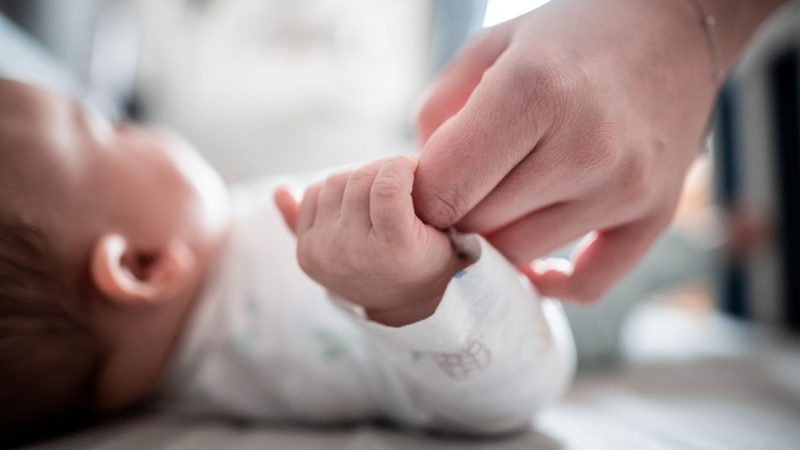 Ein Baby klammert sich an den Finger seiner Mutter. In Italien kommen immer weniger Babys zur Welt.