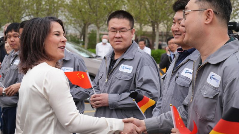 Außenministerin Annalena Baerbock (Grüne) wird beim Besuch der Flender GmbH in Tianjin von Arbeitern begrüßt. Dort werden Getriebe und Antriebskomponenten für Windturbinen montiert.