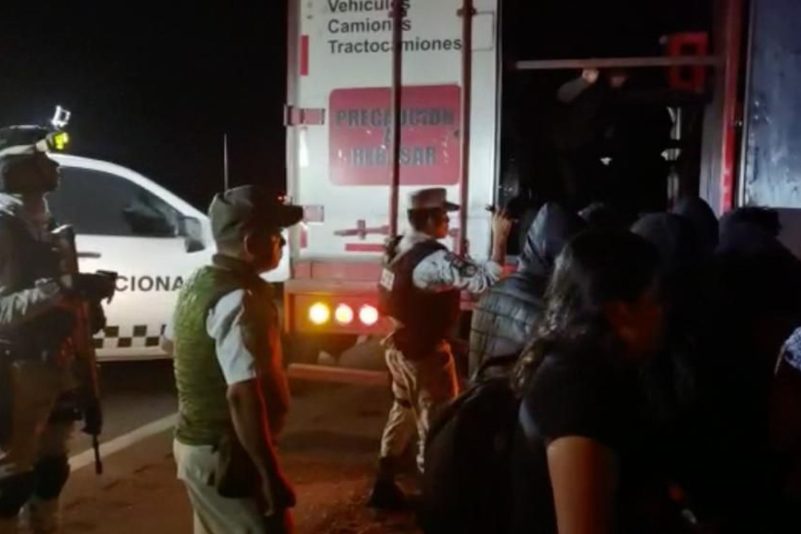 Migranten verlassen im Beisein von Sicherheitskräften den Lastwagen - die meisten von ihnen stammen aus Guatemala.