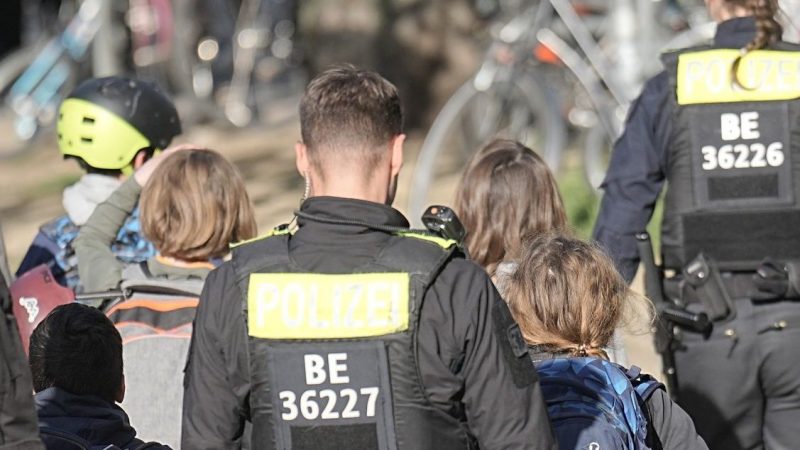 Polizisten geleiten Kinder weg vom Tatort an der Schule in Berlin-Neukölln.