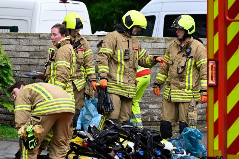 Feuerwehrleute beenden ihren Einsatz am Tatort.  Nach der Explosion in einem Ratinger Hochhaus ist in der Wohnung eine Leiche gefunden worden.