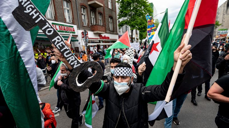 Teilnehmer einer Palästinenser-Demonstration laufen durch Neukölln.