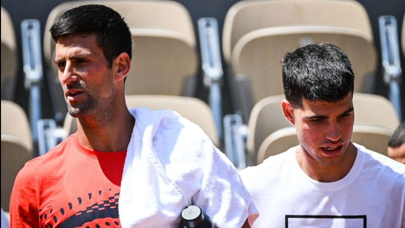 Novak Djokovic (l) aus Serbien und Carlos Alcaraz aus Spanien gehen nebeneinander während einer Trainingseinheit für die French Open 2023.