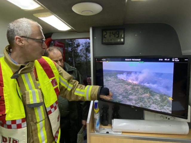 Der Feuerwehrkommandant Francis Cloth (l) zeigt den Moorbrand auf einem Bildschirm.