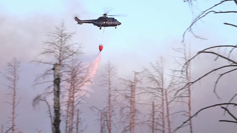 Ein Löschhubschrauber über dem Waldbrand in einem munitionsbelasteten Gebiet bei Jüterbog (Landkreis Teltow-Fläming).