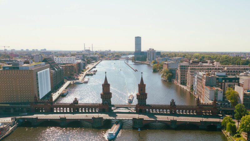 Ausflugsschiffe fahren an der Oberbaumbrücke auf der Spree in Richtung Innenstadt. (Drohnenaufnahme)