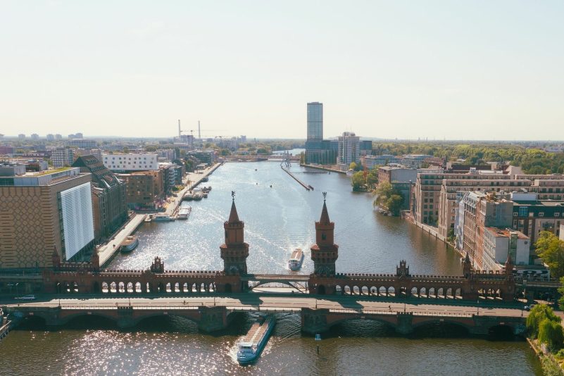 Ausflugsschiffe fahren an der Oberbaumbrücke auf der Spree in Richtung Innenstadt. (Drohnenaufnahme)