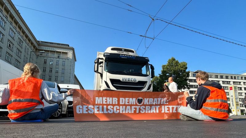 Aktivisten der Gruppe Letzte Generation blockien eine Straße in Berlin.