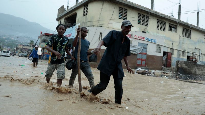 Bewohner waten über eine überschwemmte Straße nach einem starken Regen in Port-au-Prince.