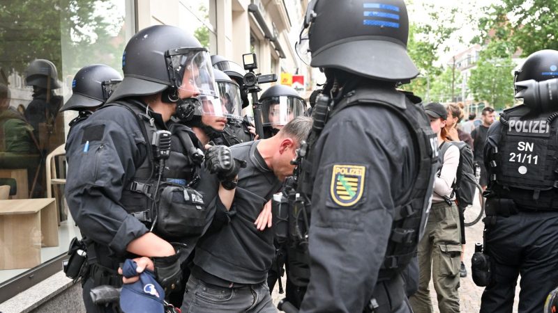 Polizisten halten einen Teilnehmer aus einer Demonstration in Leipzig fest.