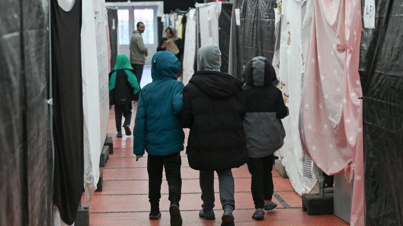 Flüchtlingskinder gehen durch ein Zelt der Flüchtlingsunterkunft.