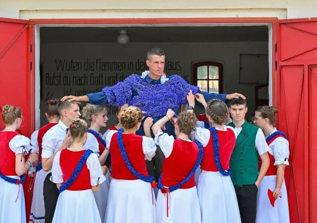 Zum Johannisreiten wird ein junger Mann im brandenburgischen Casel mit Kornblumen behängt. Die Dorfbewohner versuchen dann, ihm die Blumen abzunehmen. In dem Dorf nahe Cottbus wird der sorbische Brauch noch heute gepflegt.