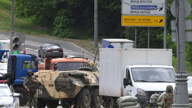Russische Armeeangehörige bewachen die Autobahn bei Moskau mit einem Mannschaftstransportwagen.