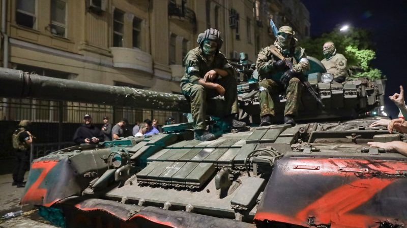 Angehörige des Militärunternehmens Wagner Group sitzen auf einem Panzer auf einer Straße in Rostow am Don, Russland, bevor sie einen Bereich im Hauptquartier des südlichen Militärbezirks verlassen.