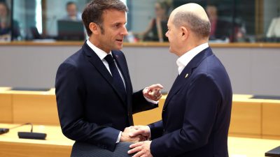 Frankreichs Präsident Emmanuel Macron spricht mit Bundeskanzler Olaf Scholz (SPD) während eines Treffens am runden Tisch im Gebäude des Europäischen Rates am zweiten Tag eines EU-Gipfels.