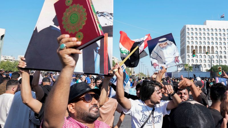 Anhänger des schiitischen Geistlichen Muqtada al-Sadr erheben den Koran, das heilige Buch der Muslime, während einer Demonstration vor der schwedischen Botschaft in Bagdad.