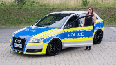Die Autotunerin Svenja Geertz steht neben ihrem  Audi, der ähnlich wie ein Polizeifahrzeug foliert ist.