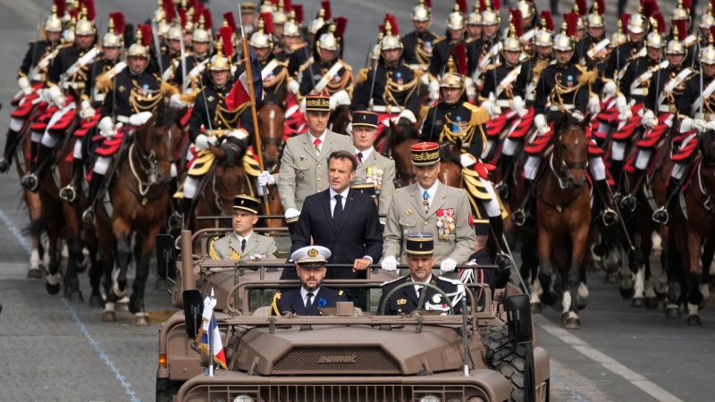 Frankreichs Präsident Emmanuel Macron in einem Kommandowagen mit General Thierry Burkhard, Chef des Generalstabes, bei der Parade auf der Avenue des Champs-Elysees. Frankreich erinnert an den Sturm auf die Bastille im Jahr 1789, der als symbolischer Beginn der Französischen Revolution angesehen wird.
