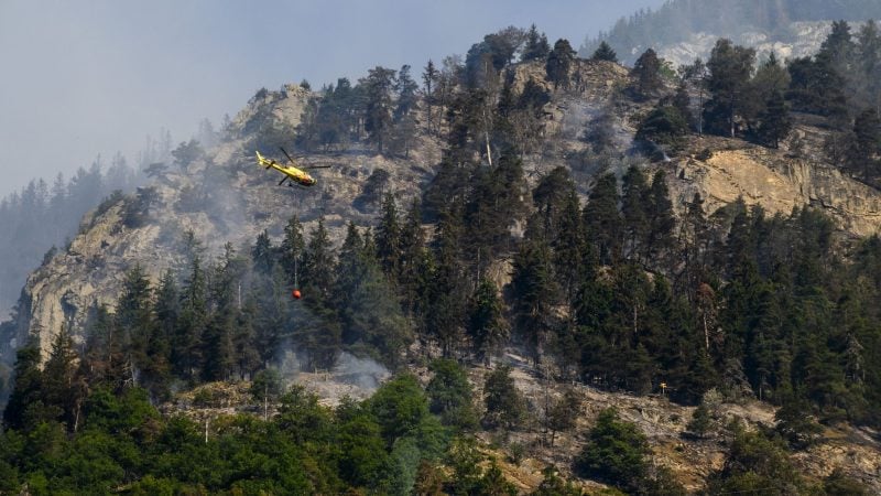 Ein Helikopter ist während eines Waldbrandes im Einsatz.