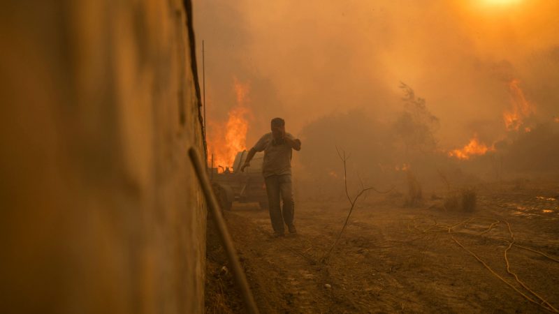 Ein Einheimischer flieht vor den Flammen von einem Waldbrand im Dorf Gennadi auf der griechischen Insel Rhodos.