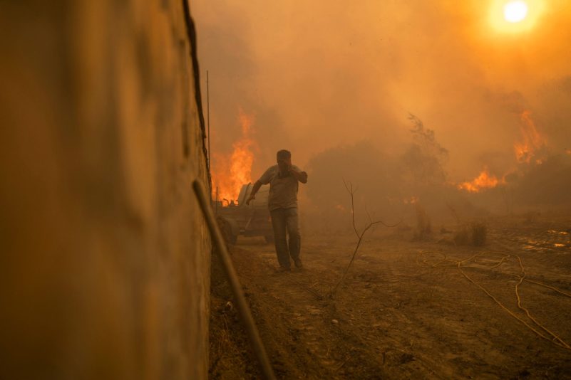 Ein Einheimischer flieht vor den Flammen von einem Waldbrand im Dorf Gennadi auf der griechischen Insel Rhodos.