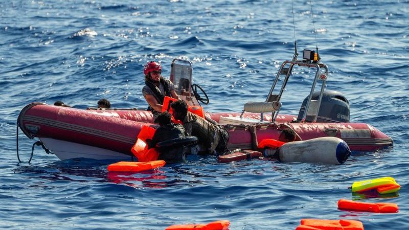 Ein Mitglied der spanischen Nichtregierungsorganisation Open Arms rettet geflüchtete Menschen aus dem Mittelmeer, nachdem ihr Holzboot südlich der italienischen Insel Lampedusa gekentert ist.