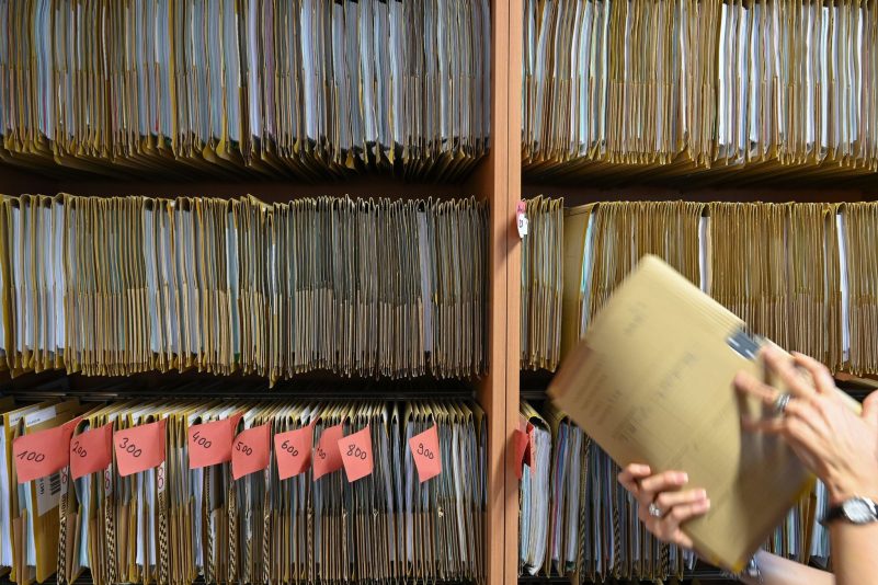 Eine Mitarbeiterin des Amtsgerichts Frankfurt greift an einem Regal nach einer Gerichtsakte. Der digitale Wandel in der hessischen Justiz ist mit der Einführung der E-Akte ein weiteres Stück vorangekommen.